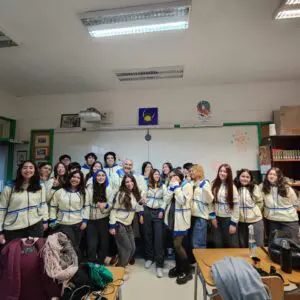 Estudiantes de 4to medio sonrientes en polerones crema y celeste, celebrando juntos.