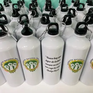 Botellas blancas con logo y mensaje de lucha por derechos laborales y unidad.