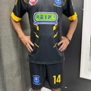 Uniforme de fútbol moderno en negro y amarillo con diseño impactante y sponsor REIPO.