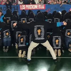 Reunión comunitaria en apoyo a prisioneros, con polerones negros y mensajes de activismo.