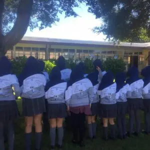 Estudiantes de secundaria celebrando juntas en su día especial con polerones grises.