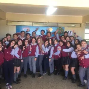 Estudiantes de cuarto medio celebrando la graduación en el corredor de la escuela.