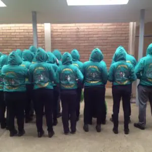 Grupo de 4to medio con polerones turquesa, destacando unidad y compañerismo.