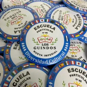 Chapitas de identificación para la Escuela Particular N°46 Los Guindos, promoviendo la diversidad cultural.