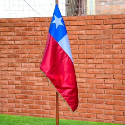 Bandera chilena ondeando en un entorno acogedor y significativo, con un fondo de ladrillo.