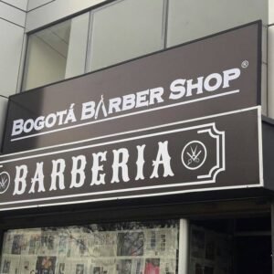 Letrero vintage de barbería en Bogotá con nombre y detalles decorativos atractivos.