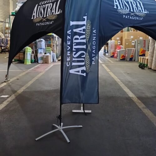 Promoción de Cerveza Austral con carpa y bandera en evento interior.