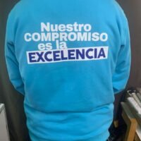 Sudadera azul con mensaje motivacional sobre compromiso y excelencia.