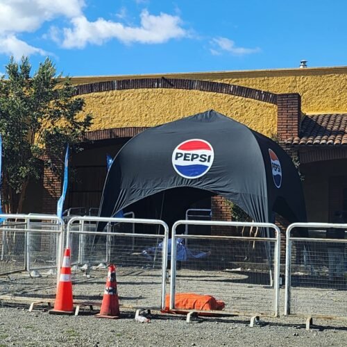 Evento promocional de Pepsi con carpa en un ambiente soleado al aire libre.