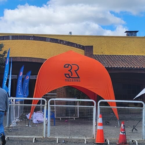 Toldo naranja personalizado para eventos en un encantador lugar rústico.