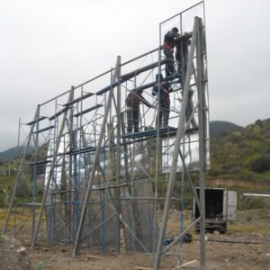 Construcción de andamios en un paisaje natural con trabajadores en acción.