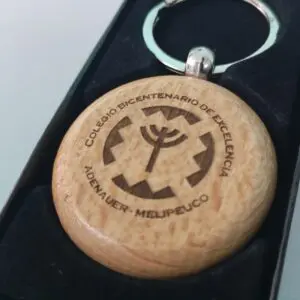 Llaveros personalizados en madera con diseño simbólico para instituciones educativas.